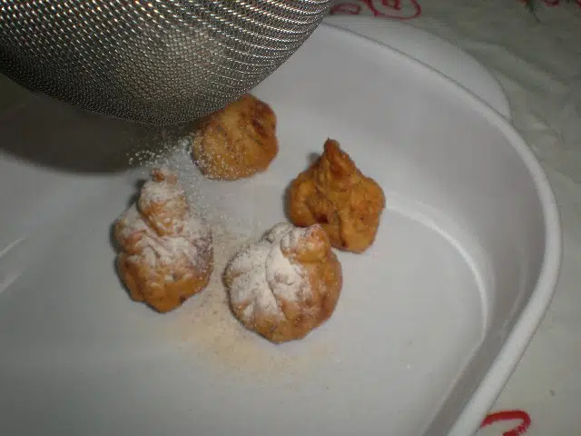 Echar azúcar a los saquitos rellenos Echar azúcar a los saquitos rellenos