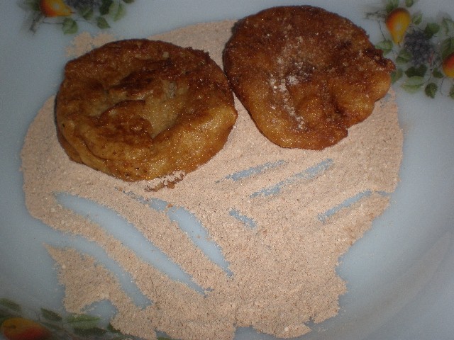 Pasar las torrijas de manzana por azúcar y canela 