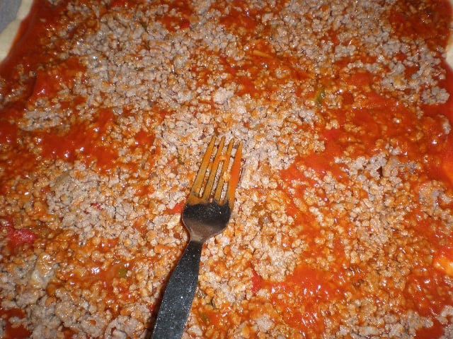 Masa de pizza con tomate y carne