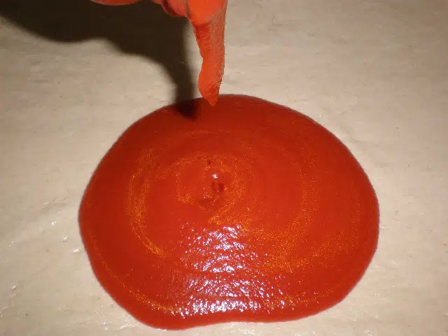 Poner tomate a la pizza