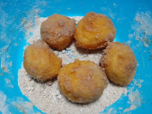 Pasar los buñuelos por el azúcar